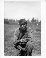 F061: William Pascal, kneeling outside, portrait, Pauningassi, Manitoba, circa 1930s