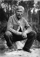 A011: Chief William Berens, squatting outside with pipe, Berens River, Manitoba, circa 1930-1933