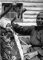 A014: Nancy Berens (Everett) and a grandchild in a mossbag and tikanagan, Berens River, Manitoba, circa 1930-1933