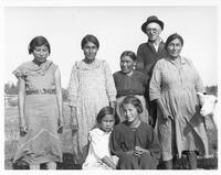 A039: Group portrait of seven Ojibwe people, in a field, Berens River, Manitoba, circa 1930-1938