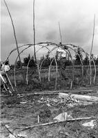 A097: Getagaash Keeper and boy, tying down cross poles of a waaginogaan, Little Grand Rapids, Manitoba, 1934