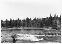 A051: Ojibwe man with pack, en route on Berens River, between Poplar Hill and Little Grand Rapids, Manitoba, 1933