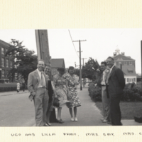 Ugo and Lilla Fano, Mrs. Sax, Mrs. Carlson, Carlson and Sax standing outside on sidewalk with buildings in background.