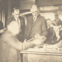 Unidentified men around a table, foreground figure blurry.