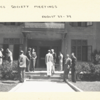 Group of men standing outside of building during the Genetics Society Meeting.