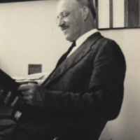 Osterhout, seated looking at a book, Woods Hole, 1921.