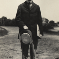 Harrison, standing outside holding hat, Woods Hole, 1921.