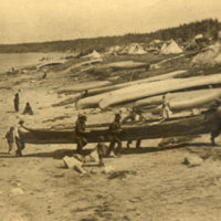 9-50-a: View of men carrying canoe from water to encampment.