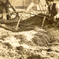 9-16-m: Two men working on canoe.