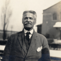 9-17-c: Portrait of man in suit, standing outside.