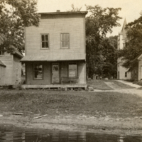 9-11-d: Houses and church, stream in foreground.