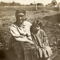 9-8-g: Woman and child, seated outside.