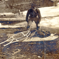 9-7-n: Young man with snow shoes and drag sled.