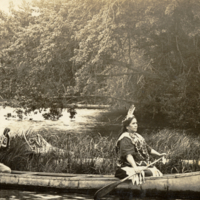 9-1-e: Penobscot chief and wife in birch bark canoe with curve decorations at ends