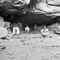 Three Tepecano men, sitting under rock formation