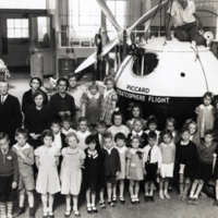 Group portrait of children, standing, near Piccard Stratosphere Flight vessel.