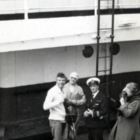 View of Swann, standing with others, on ship.