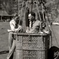 View of two unidentified men, one standing in balloon basket.