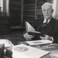 William Ezra Lingelbach, seated at desk, reading book.