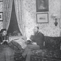 Rev. R. M. Chipman (?), seated, reading book.