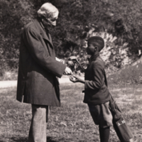 John D. Rockefeller and unidentified boy, profile, standing, informal.