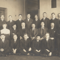 Simon Flexner, Hideyo Noguchi, 19 unidentified men, and two unidentified women, formal, 13 seated and 10 standing at the Rockefeller Institute.