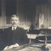 Harry M. [Thorias], half length, informal seated at desk.