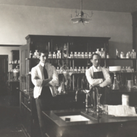 Three men standing in laboratory at Rockefeller Institute.