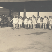 Dancing children in white dresses.