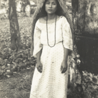 Unidentified  woman, full length, standing wearing her typical rain coat, philippines.