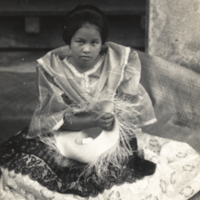 Girl seated, wearing dress.