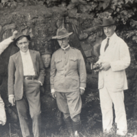 Heiser and three unidentified men standing in front of carved rock, Central America.