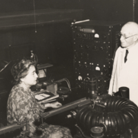 W. J. V. Osterhout and wife, half length, profile, informal, he is standing, she is seated in laboratory at the Rockefeller Institute for Medical Research.