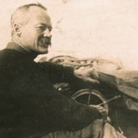 Wilfred Thomason Grenfell, half length, profile, informal, seated steering a  boat.