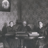 F8.2.19 Boas family, seated, around table.