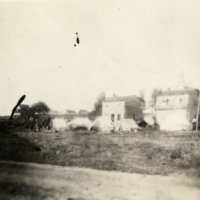 5-30-i: Four tents in front of wooden buildings