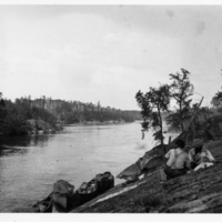 A-059: Berens River by canoe, steep bank, two men and boats