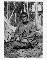 A-302: Ojibwa woman, portrait, kneeling outside 