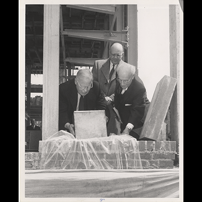 2. Librarian William E. Lingelbach hands over material to President William J. Robbins so that he can place it in the cornerstone.