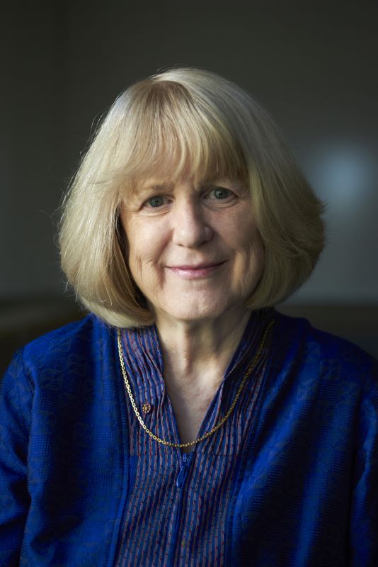 Portrait of King smiling and wearing a dark blue blouse.