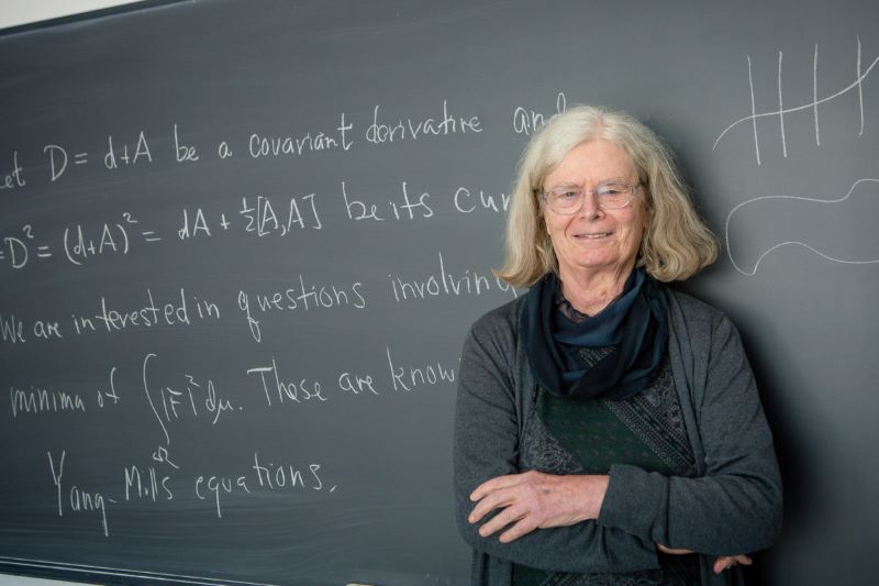 Karen Uhlenbeck standing in front of a chalkboard.